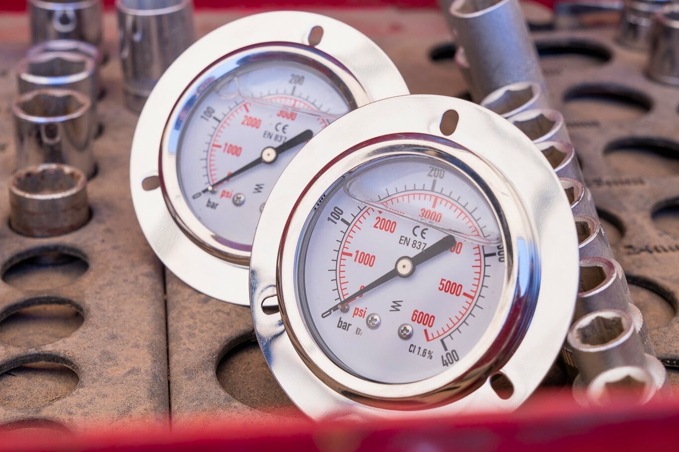 Closeup of two Heavy Haul Pressure Gauges sitting on a work bench